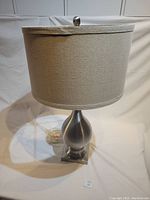 Front view of table lamp showing brushed aluminum base and canvas shade