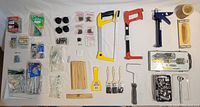 Photo showing various hand tools including hacksaws, scraper, caulk tool, paint brushes, sanding supplies, and sockets.