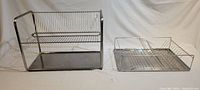 Side by side view of the two stainless steel dish drying racks on a white backdrop.