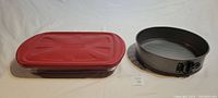Photo showing the Pyrex casserole dish with fitted red lid and the 10" non-stick springform cake pan side by side.