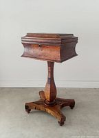 Front side view of the antique rosewood tea caddie showing box top and pedestal base.