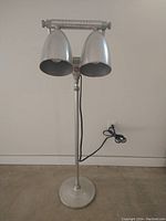 Full view of the lamp showing base, pole, dual heads and cord.