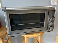 Front view of stainless steel toaster oven on stool