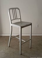Full side view of vintage aluminum counter stool showing overall construction and height.