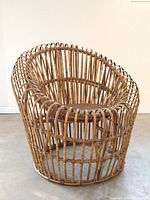 Front angle view of circular bamboo chair with open-weave frame and cane seat
