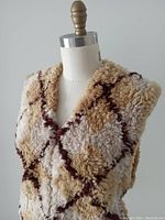 Front and angled front view of original knit beaver fur vest showing diamond pattern in beige, brown, and cream colors on fur with hook and ring closure.