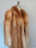 Side view of red fox fur coat on dress form