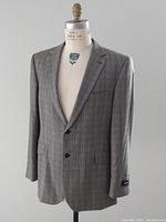 Front view of the men's checkered suit jacket on a mannequin, showing the style and cut.