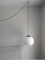 Full view of lamp hanging from ceiling chain