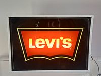 Front view of illuminated sign against white wall