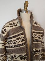 Front angled view of thick brown and cream Cowichan wool sweater on dress form showing collar and pattern detail.