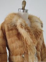 Close-up photo showing the thick collar and plush red fox fur with herringbone pattern, highlighting texture and color.
