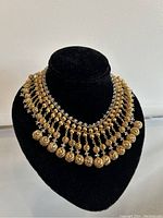 Front view of the gold tone costume jewelry vintage choker necklace on a black display bust.