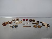 Front view showing full collection of vintage cufflinks and two tie clips arranged in a row for size comparison.