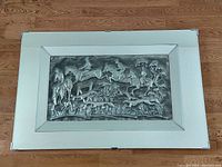 Full view of large high relief fox hunting scene mounted in a mirror frame placed on floor.