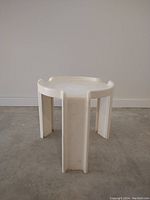 Full view of off-white plastic side table showing the front angle and structure.
