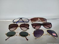 All six pairs of vintage sunglasses displayed in two rows on a flat surface.
