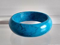 Front view of the chunky turquoise bangle bracelet showing color and veining