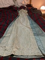 Full front view of the blue dress showing the satin panels and the brocade overlay.