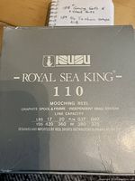 Photo of the outer box for the Tesu Royal Sea King 110 Mooching Reel showing model details and technical specs such as graphite spool and frame, line capacity, and drag system.