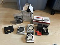 Photo showing Canon Speedlite 540EZ flash and various boxed lens filters and caps on hardwood floor.