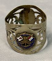 Front view of the napkin ring showing enamel emblem with crossed flags and text 'R.M.S. ATHENIA'.