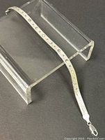 Sterling silver bracelet displayed on acrylic stand showing full length and engraved celestial designs.