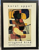 Full image of the framed Karel Appel gallery show poster titled 'Vraggend Kind'. Black frame, white matting with text in Dutch and abstract colorful figure artwork.