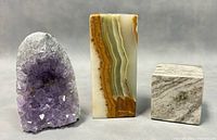 Three stone items displayed: amethyst geode, onyx pen holder, and Connemara marble cube.