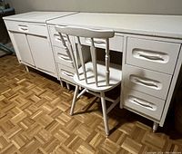 Full view of desk, chair, and cabinet showing front and side profiles with parquet flooring.