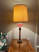 Full lamp lit with pleated silk shade, showing overall height and glow