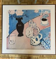 Framed impressionist style still life poster showing flowers in different vessels and a glass on a birch wood floor.