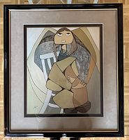 Framed print shows the full artwork with a stylized figure sitting with hands clasped, beige/brown color scheme, mounted and framed with glass.