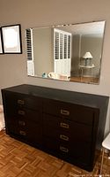 Dresser and mirror against wall showing dresser front and full mirror reflection.
