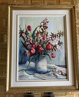 Full view of oil painting with pink flowers in vase and gold ornate frame