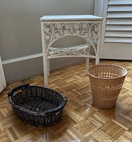 Side view showing the white painted rattan side table with ornate scroll design, alongside 2 baskets.