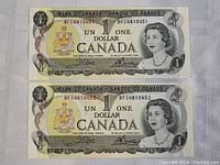 Two 1973 Canadian one-dollar banknotes with serial numbers BFC4810451 and BFC4810452.