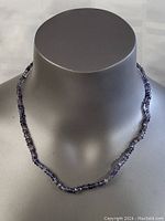 Front view of amethyst stone necklace displayed on a gray mannequin bust, showing the full length and the natural purple coloration of the stones.