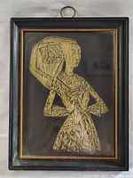 Frontal full view of the framed rubbing art showing the woman in traditional attire, framed with a wood and gold trim frame.