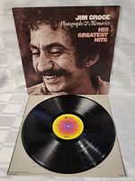 Vinyl record with central label showing, placed outside cover, showing condition of vinyl and label.