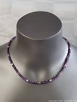 Front view of the necklace displayed on a gray mannequin bust showing amethyst beads, pearls, and silver accents.