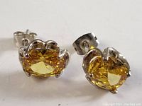 Close-up photo of both sterling silver citrine earrings showing oval yellow-orange faceted stones in prong settings