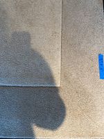 Close-up of the beige textured surface of the rug showing its pile and color.