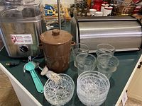 Full set of kitchenware items on counter including glass bowls, canister, bread box, glasses, ice cream scoop, ice cream maker, and paper towel holder