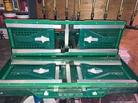 Folded green collapsible camping table showing plastic slats and metal frame.
