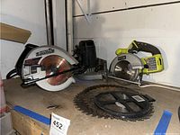 Photo showing Craftsman circular saw, Ryobi circular saw, and several extra circular saw blades on a shelf.