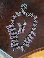 Full view of necklace and earrings laid out on wooden surface