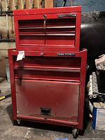 Front view of stacked Task Force red toolboxes, large cabinet on bottom with wheels, smaller chest on top, both lockable.