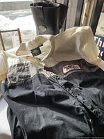 Photo showing Harley Davidson shirt with Racing patch and collar tag, with motorcycle boots in background