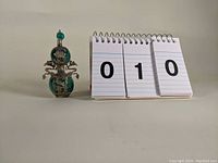 Front view of double orb snuff bottle with turquoise orbs and metal dragon mountings.